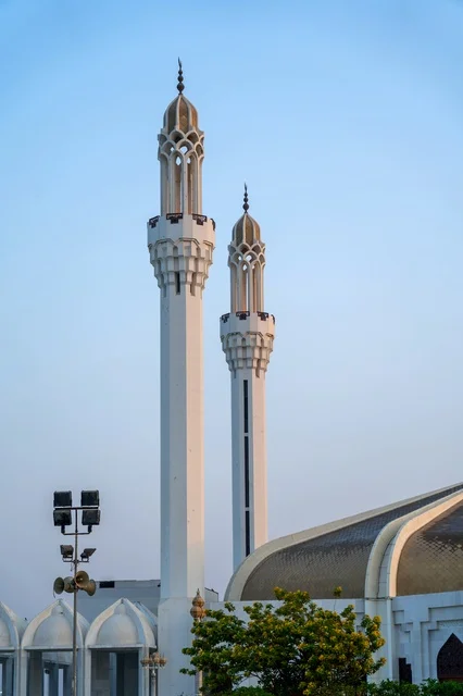White Mosque Minarets Standing Against Clear Blue Sky