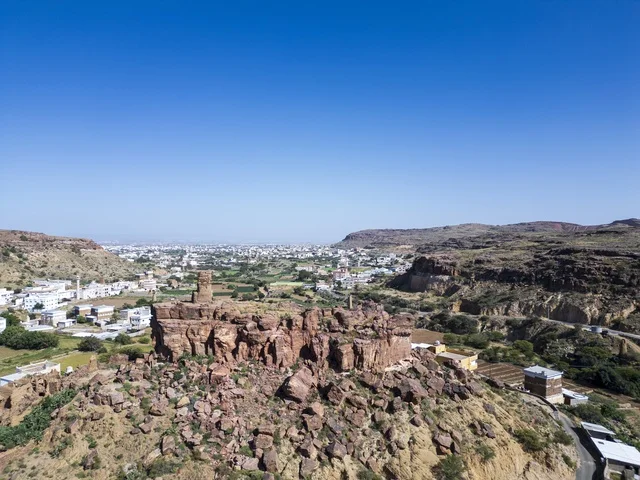 بقايا قلعة حجرية أثرية على تلة جبلية في الوادي
