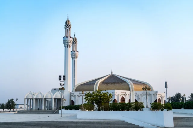 تصميم معماري لمسجد أبيض حديث مع قبة ذهبية مميزة