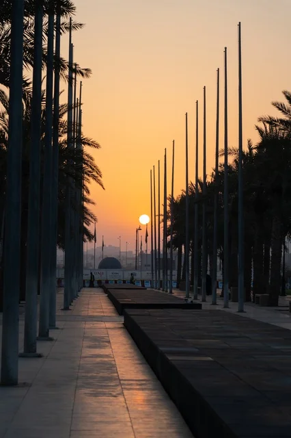 Sunset over Public Plaza with Palm Trees and Flagpoles