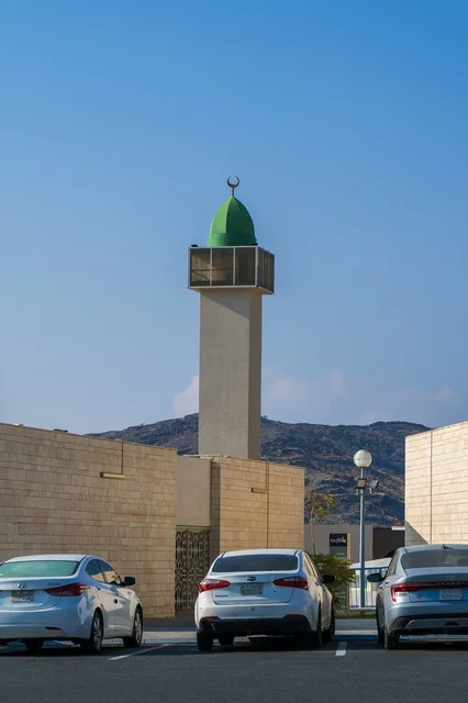Modern Mosque Minaret and Parking Lot Under Blue Sky