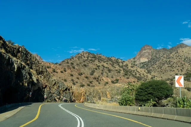 طريق جبلي متعرج تحت سماء زرقاء صافية