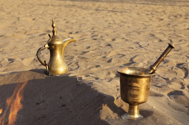 هاون نحاسي ودلة قهوة تقليدية في صحراء عمان