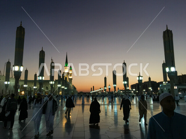 صورة لساحة المسجد النبوي الشريف في المدينة المنورة بالمملكة العربية السعودية وقت الغروب، الحرم النبوي الشريف، ​المصلين المعتمرين، موسم الحج والعمره ، المظلات الإلكترونية الضخمة داخل المسجد النبوي الشريف ، العبادة والتقرب إلى الله، المعالم الدينية بالسعودي