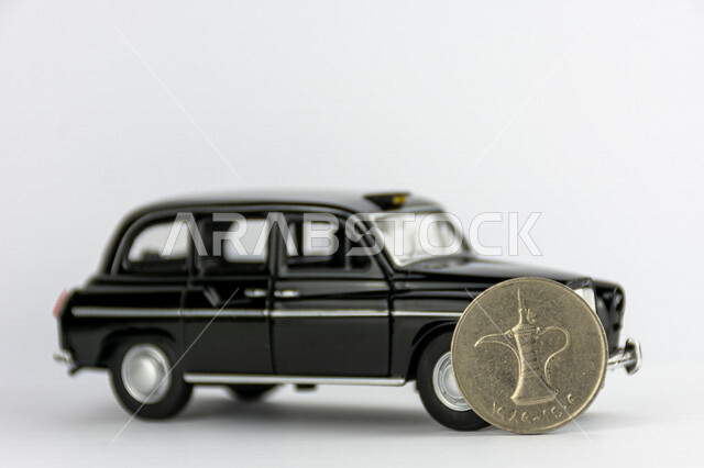 صورة لعملة الدرهم الإماراتي، درهم إماراتي من فئة 1 درهم، صورة الدلة مطبوعة على عملة الدرهم، مجسم لسيارة كلاسيكية سوداء، عملات معدنية، مالية واقتصاد، خلفية بيضاء