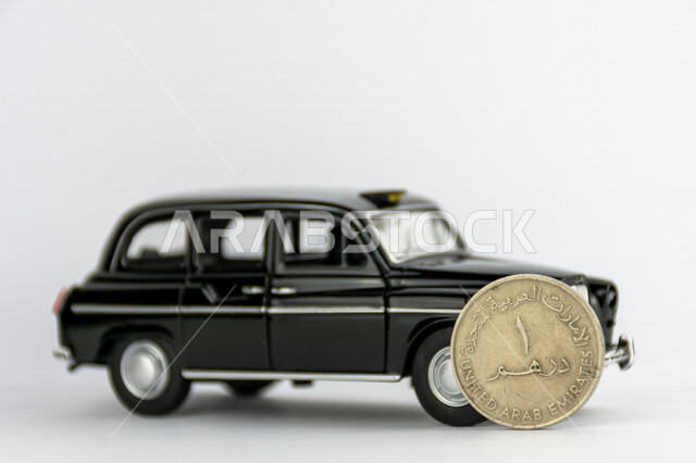 صورة لعملة الدرهم الإماراتي، درهم إماراتي من فئة 1 درهم، مجسم لسيارة كلاسيكية سوداء، عملات معدنية، مالية واقتصاد، خلفية بيضاء