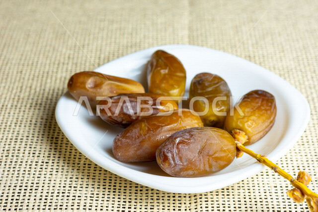 A close-up of a plate of healthy dates, Deglat Nour dates, a meal with a high nutritional value, Ramadan hospitality, types of healthy and delicious dates