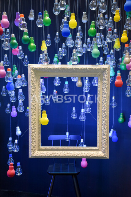 عمل فني  لبرواز مزخرف مع كرسي ومصابيح ملونة في المعرض الدولي للكتاب بأبو ظبي ، فعاليات ومعارض كتاب في الإمارات ، أعمال فنية ، السياحة في الإمارات العربية المتحدة ، معرض أبوظبي الدولي للكتاب 2022 