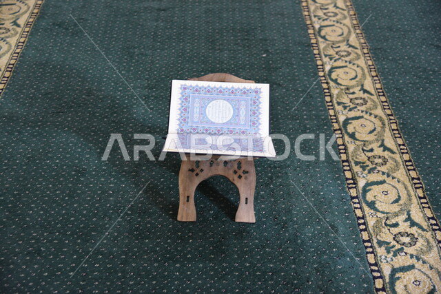 المصحف الشريف على حامل خشبي في المسجد، الصلاه والدعاء في المسجد، العبادة والتقرب الى الله، قراءة وتلاوة القران، التعبد في بيوت الله، ذكر الله، تحفيظ القران الكريم، تفسير القرآن