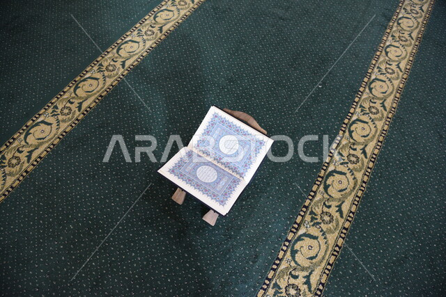 المصحف الشريف على حامل خشبي في المسجد، الصلاه والدعاء في المسجد، العبادة والتقرب الى الله، قراءة وتلاوة القران، التعبد في بيوت الله، ذكر الله، تحفيظ القران الكريم، تفسير القرآن