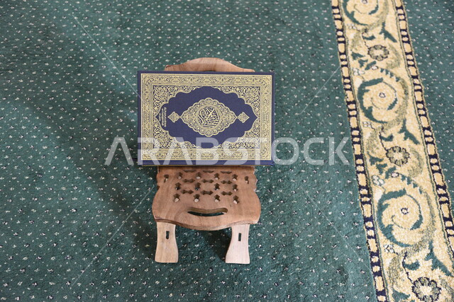 المصحف الشريف على حامل خشبي في المسجد، الصلاه والدعاء في المسجد، العبادة والتقرب الى الله، قراءة وتلاوة القران، التعبد في بيوت الله، ذكر الله، تحفيظ القران الكريم، تفسير القرآن