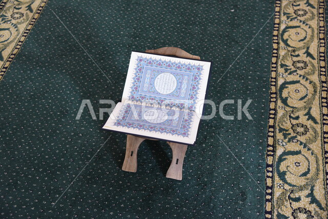 المصحف الشريف على حامل خشبي في المسجد، الصلاه والدعاء في المسجد، العبادة والتقرب الى الله، قراءة وتلاوة القران، التعبد في بيوت الله، ذكر الله، تحفيظ القران الكريم، تفسير القرآن