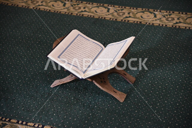 المصحف الشريف على حامل خشبي في المسجد، الصلاه والدعاء في المسجد، العبادة والتقرب الى الله، قراءة وتلاوة القران، التعبد في بيوت الله، ذكر الله، تحفيظ القران الكريم، تفسير القرآن