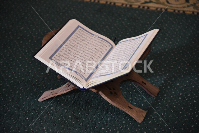 المصحف الشريف على حامل خشبي في المسجد، الصلاه والدعاء في المسجد، العبادة والتقرب الى الله، قراءة وتلاوة القران، التعبد في بيوت الله، ذكر الله، تحفيظ القران الكريم، تفسير القرآن