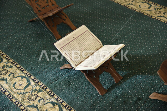 المصحف الشريف على حامل خشبي في المسجد، الصلاه والدعاء في المسجد، العبادة والتقرب الى الله، قراءة وتلاوة القران، التعبد في بيوت الله، ذكر الله، تحفيظ القران الكريم، تفسير القرآن