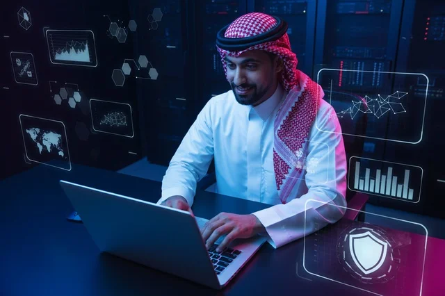 خبير أمن سيبراني سعودي يعمل على لابتوب بغرفة الخوادم