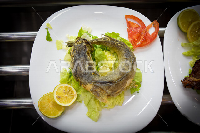 A close-up of a delicious healthy fried fish dish, fish food restaurants, oriental Arabic food, delicious meals, Arabic restaurants, healthy dish