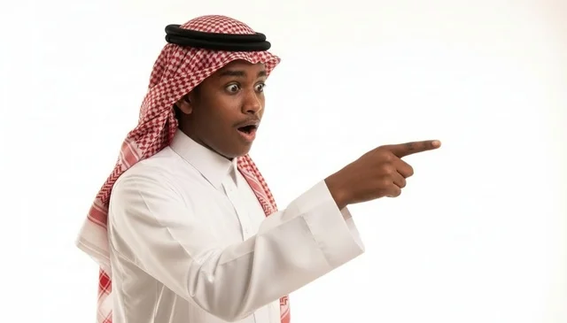 شاب سعودي متفاجئ ومصدوم يشير بإصبعه على خلفية بيضاء