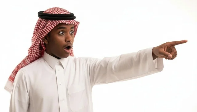 شاب سعودي متفاجئ ومصدوم يشير بإصبعه على خلفية بيضاء