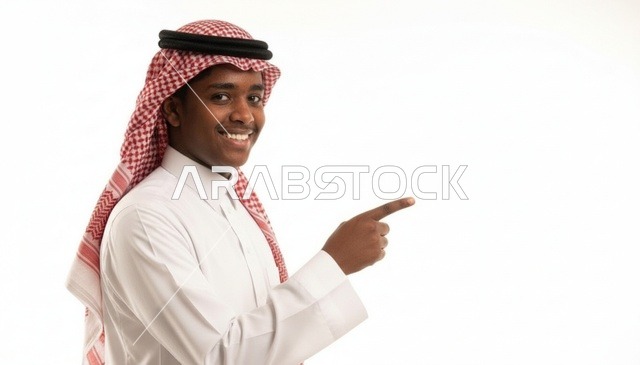 شاب سعودي مبتسم يشير بإصبعه على خلفية بيضاء نظيفة