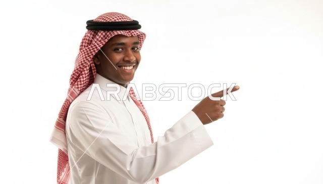 رجل سعودي مبتسم يرتدي الزي التقليدي يشير بإصبعه بخلفية بيضاء