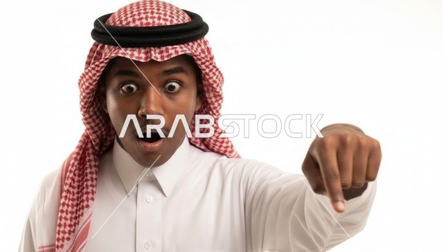 رجل سعودي متفاجئ ومصدوم يشير إلى الأسفل بخلفية بيضاء