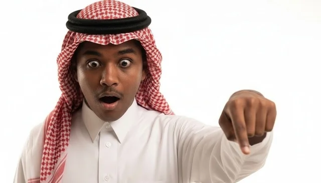 رجل سعودي متفاجئ ومصدوم يشير إلى الأسفل بخلفية بيضاء