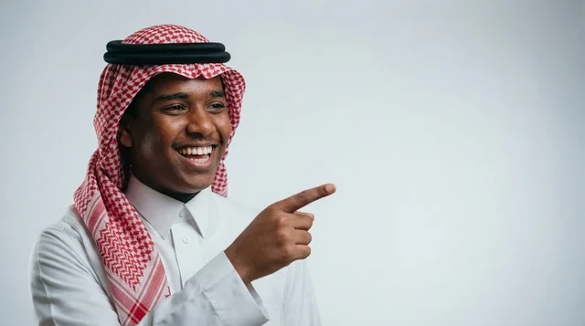 Smiling Saudi Man Pointing Finger on Studio Background