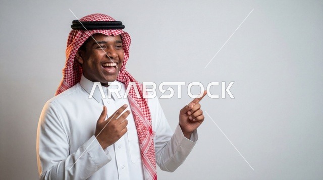 رجل سعودي بالزي التقليدي يشير لمساحة إعلانية استوديو
