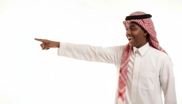 شاب سعودي مبتسم يشير بإصبعه على خلفية بيضاء