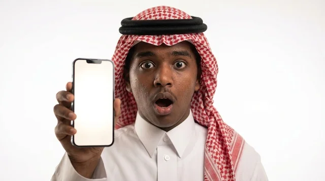 شاب سعودي مصدوم يحمل هاتف ذكي بشاشة بيضاء فارغة استوديو