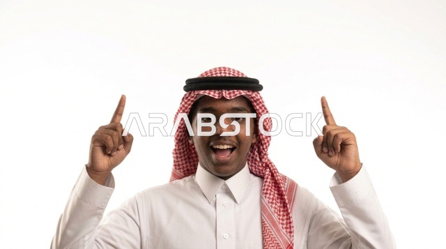 شاب سعودي بالزي التقليدي يشير للأعلى على خلفية بيضاء