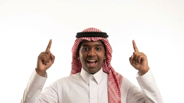 شاب سعودي بالزي التقليدي يشير للأعلى على خلفية بيضاء