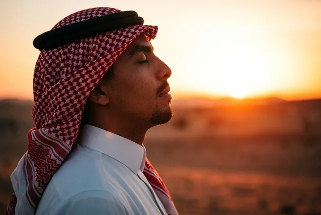 Saudi Man in Traditional Clothing at Desert Sunset