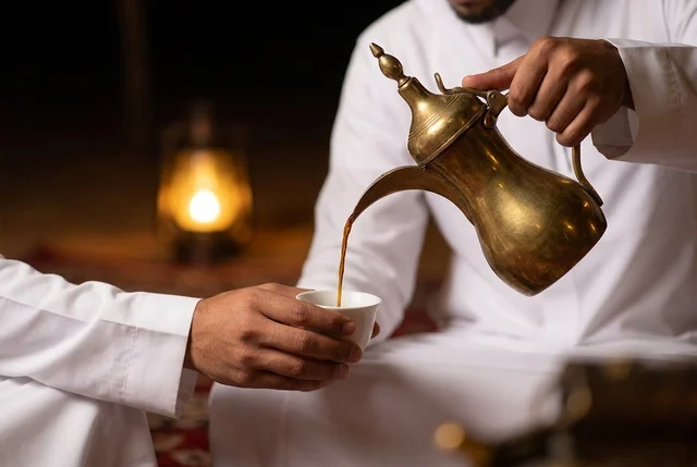 رجل سعودي يصب القهوة العربية من الدلة النحاسية