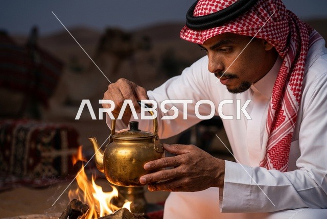 رجل سعودي يعد الشاي على شبة النار في الصحراء