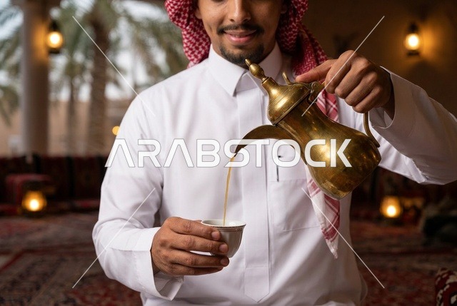 رجل سعودي يصب القهوة العربية من الدلة الذهبية التقليدية