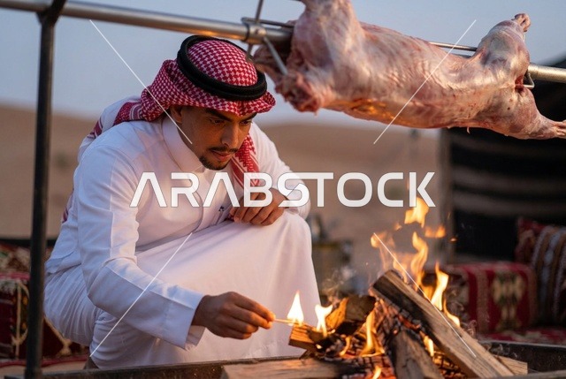 رجل سعودي يشعل النار لشواء خروف كامل في الصحراء