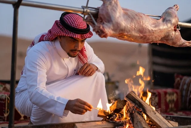 رجل سعودي يشعل النار لشواء خروف كامل في الصحراء