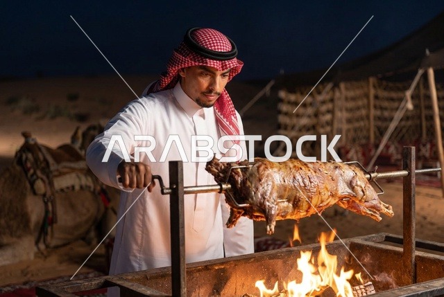 رجل سعودي يشوي خروف كامل على النار في مخيم صحراوي ليلاً