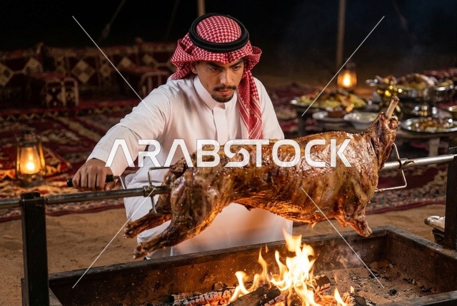 رجل سعودي يشوي ذبيحة كاملة على الجمر في مخيم صحراوي