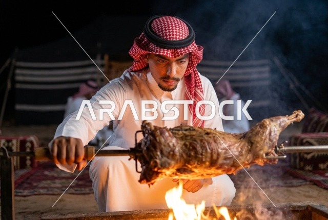 Saudi Man Roasting Lamb over Open Fire at Desert Camp