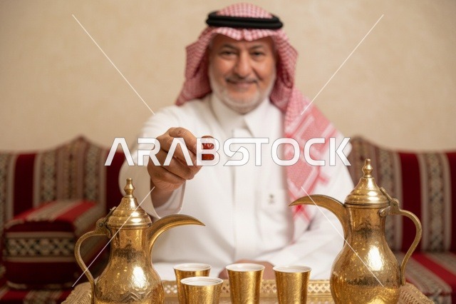 رجل سعودي مسن يقدم القهوة العربية والتمر في المجلس