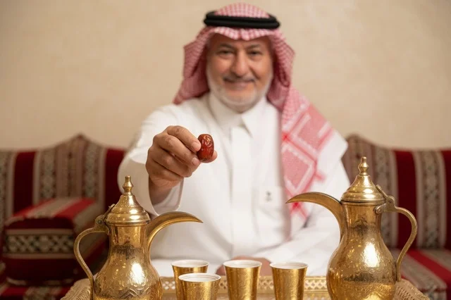 رجل سعودي مسن يقدم القهوة العربية والتمر في المجلس