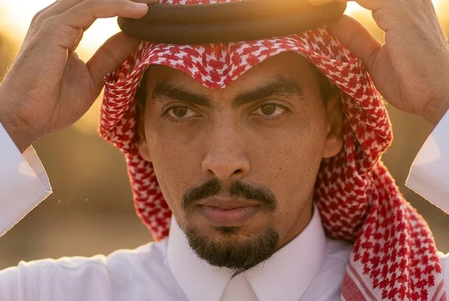 رجل سعودي يرتدي الشماغ والعقال التقليدي وقت الغروب