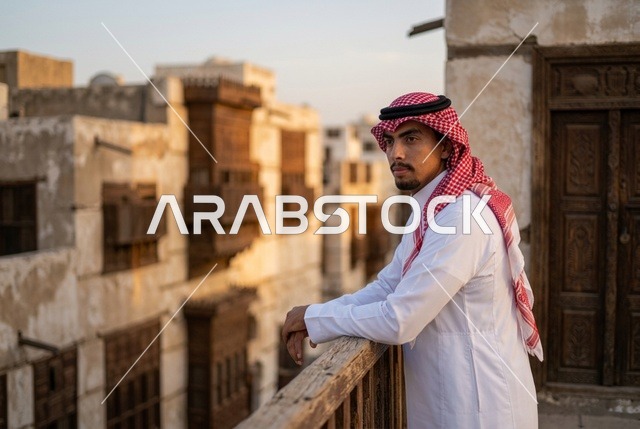 رجل سعودي على شرفة في منطقة البلد التاريخية بجدة