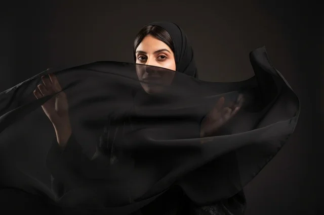 امرأة عربية بالعباءة والحجاب الأسود في الاستوديو