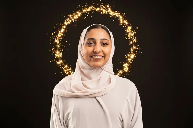 امرأة عربية مبتسمة بالحجاب مع حلقة إضاءة ذهبية بوكيه