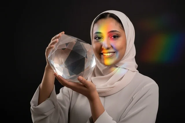 امرأة عربية تحمل منشوراً كريستالياً مع طيف ضوئي امرأة عربية تحمل منشوراً كريستالياً مع طيف ضوئي