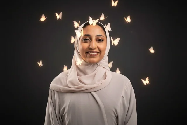 امرأة عربية بالحجاب مع فراشات مضيئة في الاستوديو